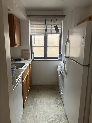 a kitchen with a refrigerator a sink and a window