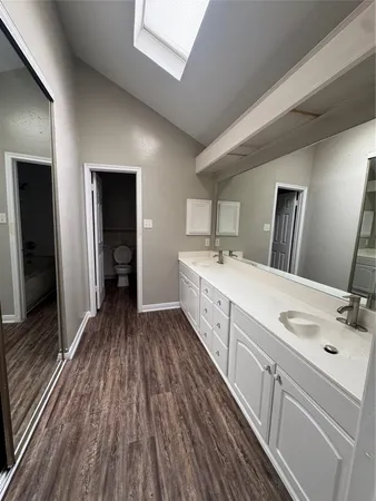 a spacious bathroom with a double vanity sink and a large mirror