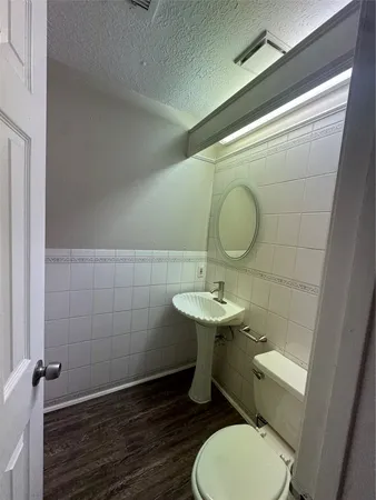 a bathroom with a toilet sink and mirror