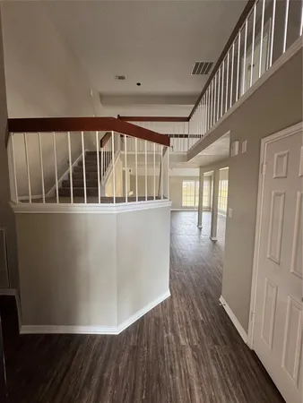 a view of a hallway with wooden floor and staircase