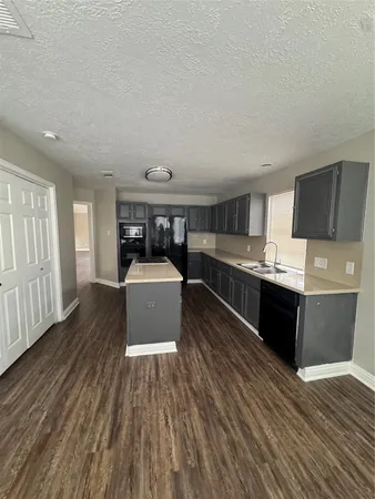 a living room with stainless steel appliances kitchen island granite countertop wooden floors and view living room