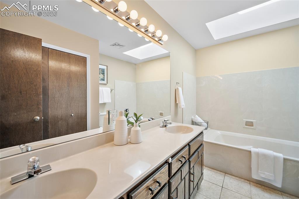 2304 Lazy R Lane Colorado Springs, CO 80915 - Photo 22 of 49 a bathroom with a granite countertop sink and a mirror