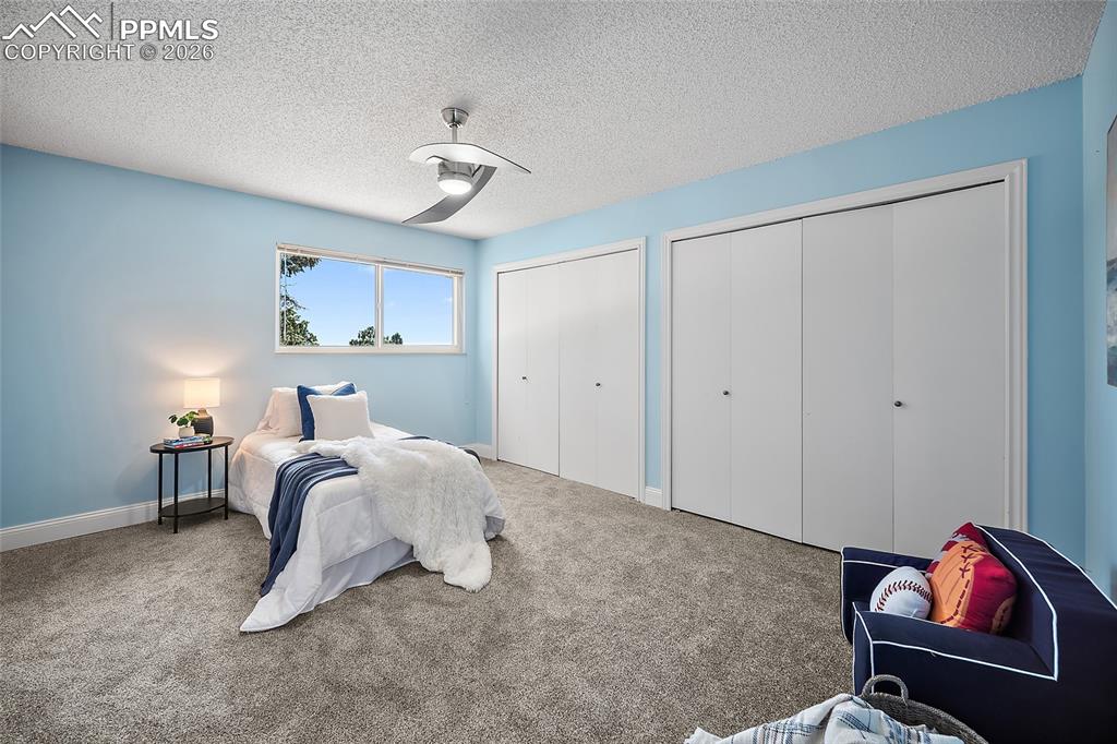 2304 Lazy R Lane Colorado Springs, CO 80915 - Photo 23 of 49 a bedroom with a bed and a chandelier