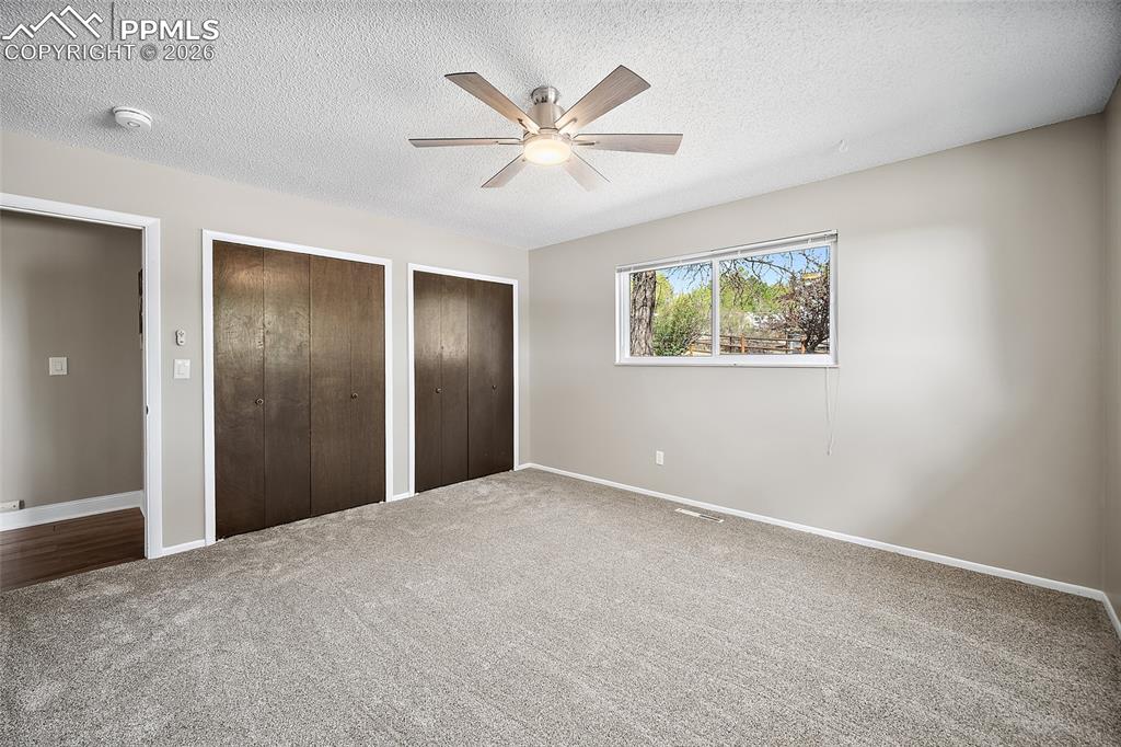 2304 Lazy R Lane Colorado Springs, CO 80915 - Photo 25 of 49 a view of an empty room with window and a ceiling fan