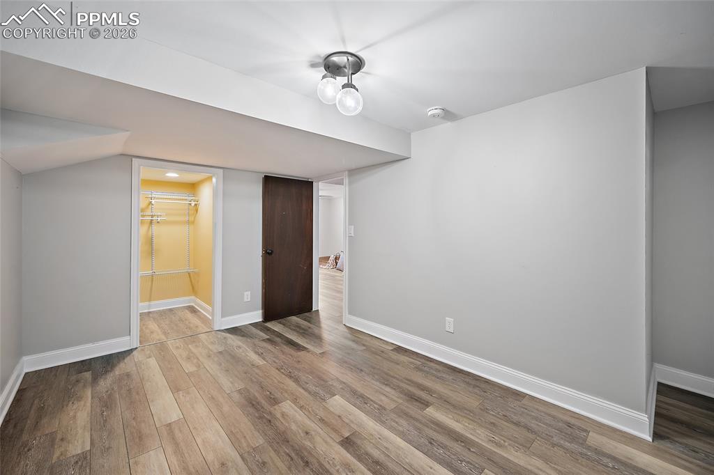 2304 Lazy R Lane Colorado Springs, CO 80915 - Photo 32 of 49 a view of an empty room with wooden floor and a window