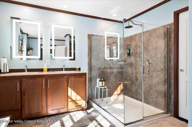 a bathroom with a granite countertop sink a mirror and shower