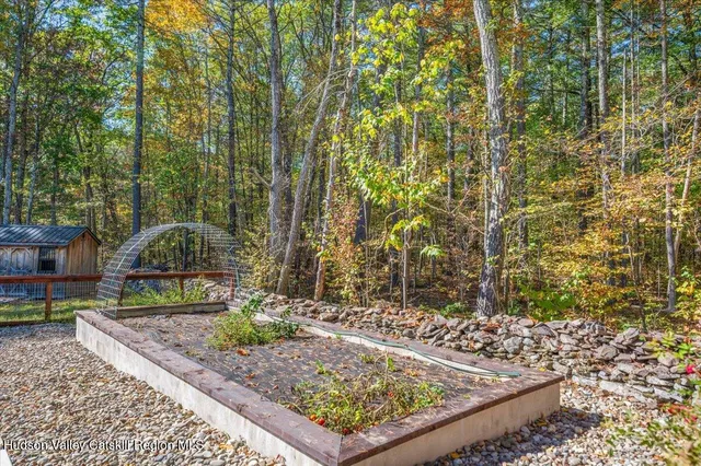 a view of a patio with table and chairs potted plants and large tree