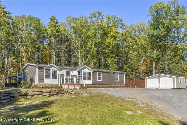 a view of a house with backyard and sitting area