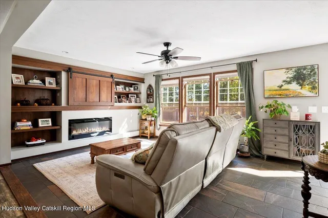 a living room with fireplace furniture and a kitchen view