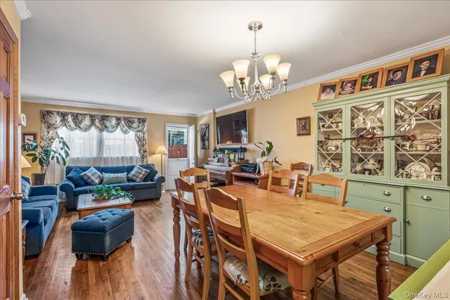 a view of a dining room with furniture a chandelier and wooden floor