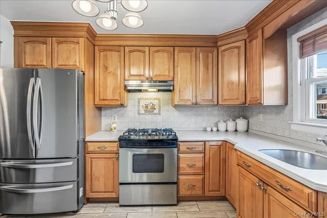 a kitchen with stainless steel appliances granite countertop a stove a refrigerator and a sink