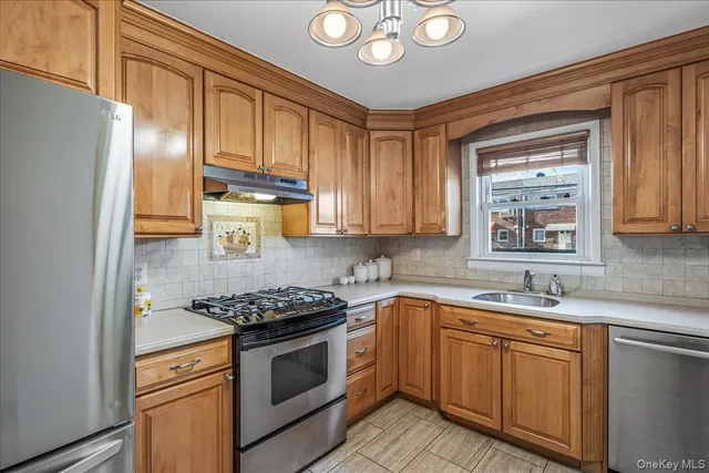 a kitchen with stainless steel appliances granite countertop a sink a stove cabinets and refrigerator