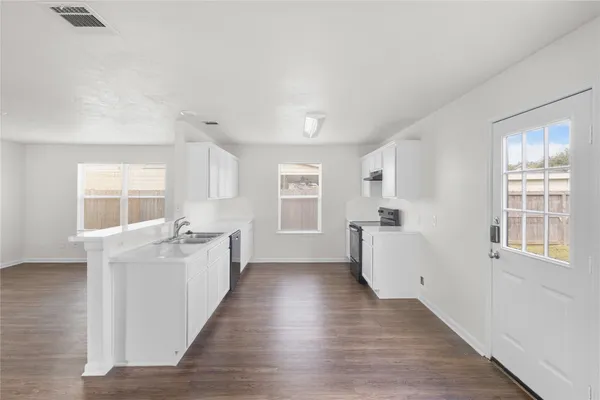 an empty room with windows and wooden floor