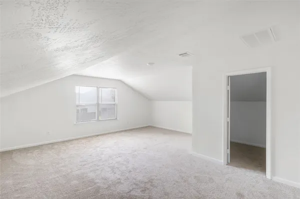 an empty room with windows and refrigerator