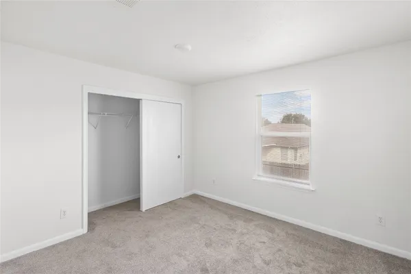 an empty room with windows and closet