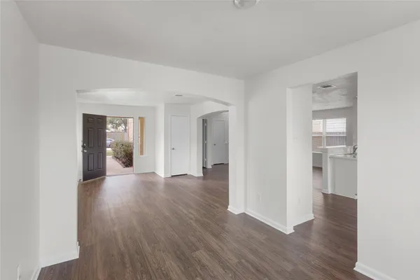a view of a hallway with wooden floor and windows