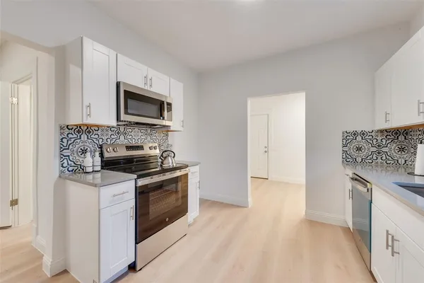 a kitchen with granite countertop cabinets stainless steel appliances and a sink
