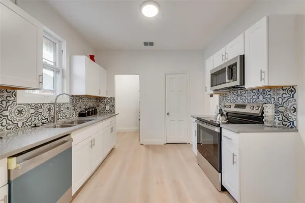 a kitchen with granite countertop white cabinets and white appliances