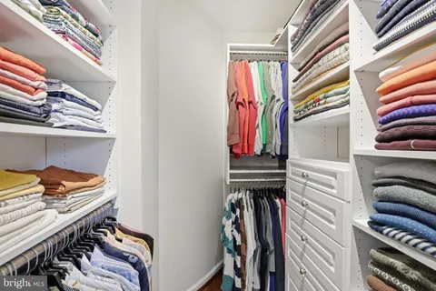 a view of walk in closet with clothes and shoes