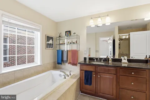 a bathroom with a granite countertop sink a mirror and a shower