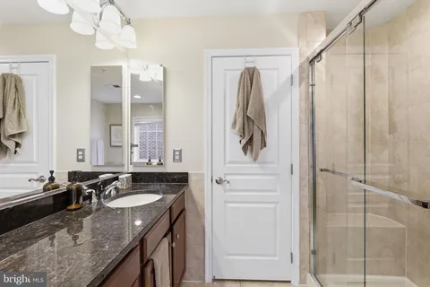 a bathroom with a granite countertop sink and a bathtub