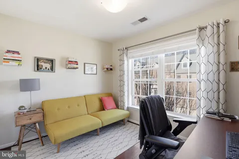 a view of a workspace with furniture and a window