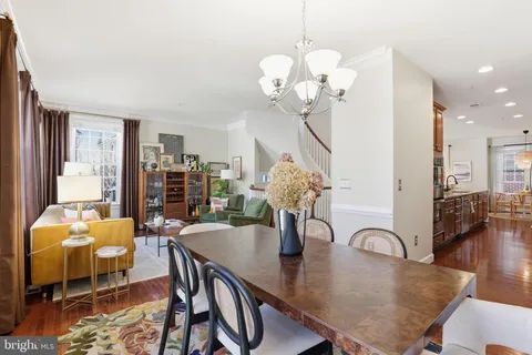 a dining room with furniture a chandelier and wooden floor