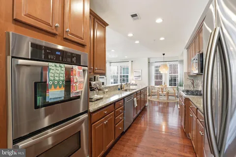 a kitchen with stainless steel appliances granite countertop a sink stove and refrigerator