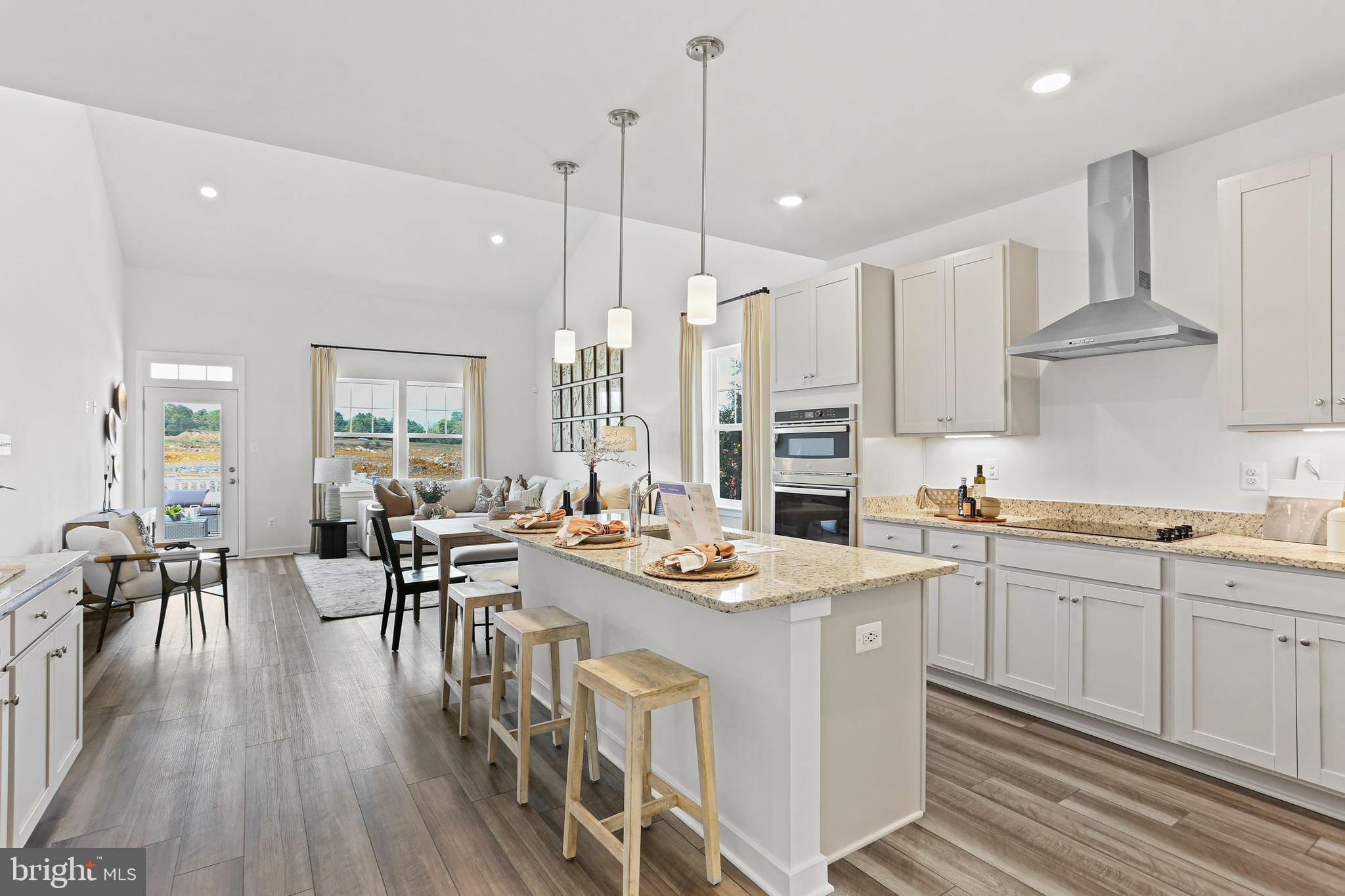 414 Silver Birch Drive Ranson, WV 25438 - Photo 4 of 15 a kitchen with stainless steel appliances granite countertop a stove a sink a kitchen island with chairs and wooden floor
