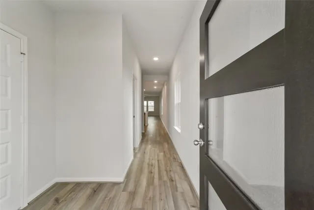a view of a hallway with wooden floor and staircase