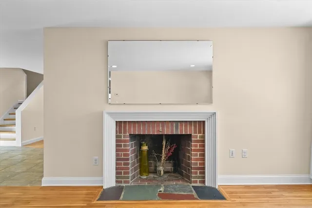 a living room with a fireplace and wooden floor