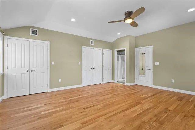 a view of a livingroom with a ceiling fan wooden floor and a ceiling fan