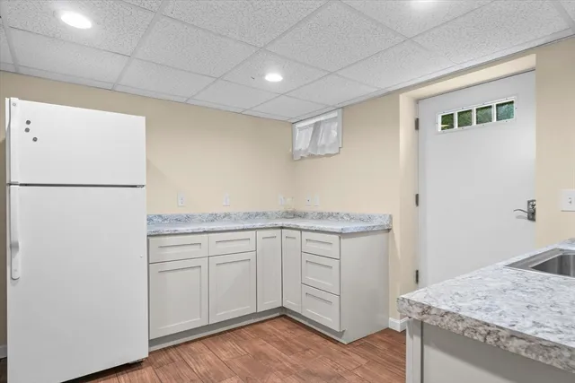 a kitchen with granite countertop white cabinets and white appliances