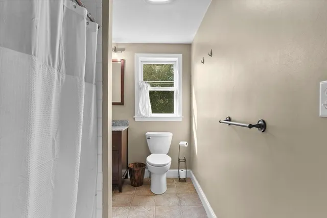 a bathroom with a toilet and a window