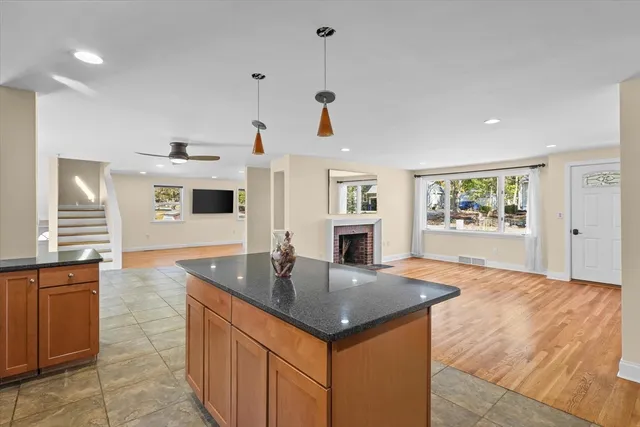 a kitchen with stainless steel appliances granite countertop a sink dishwasher and a refrigerator with wooden floor