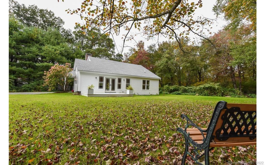 a view of a house with backyard and sitting area