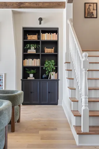 a living room with couches and kitchen view with wooden floor