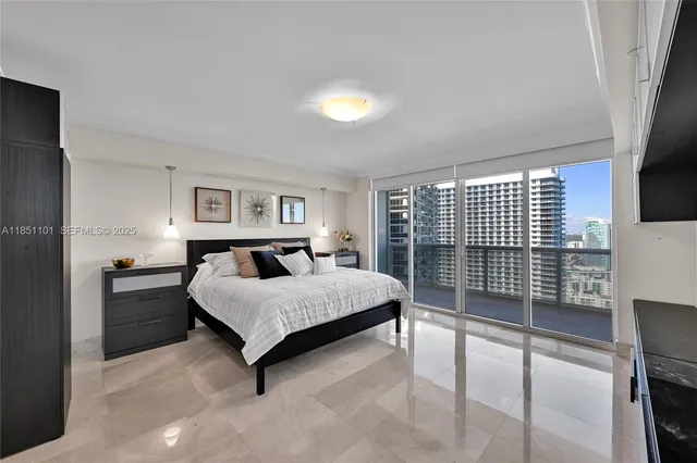 a spacious bedroom with a bed and a flat tv screen on the dresser