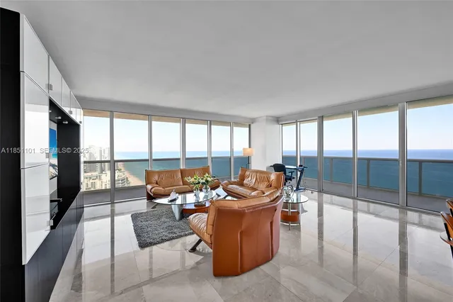 a living room with furniture and a floor to ceiling window