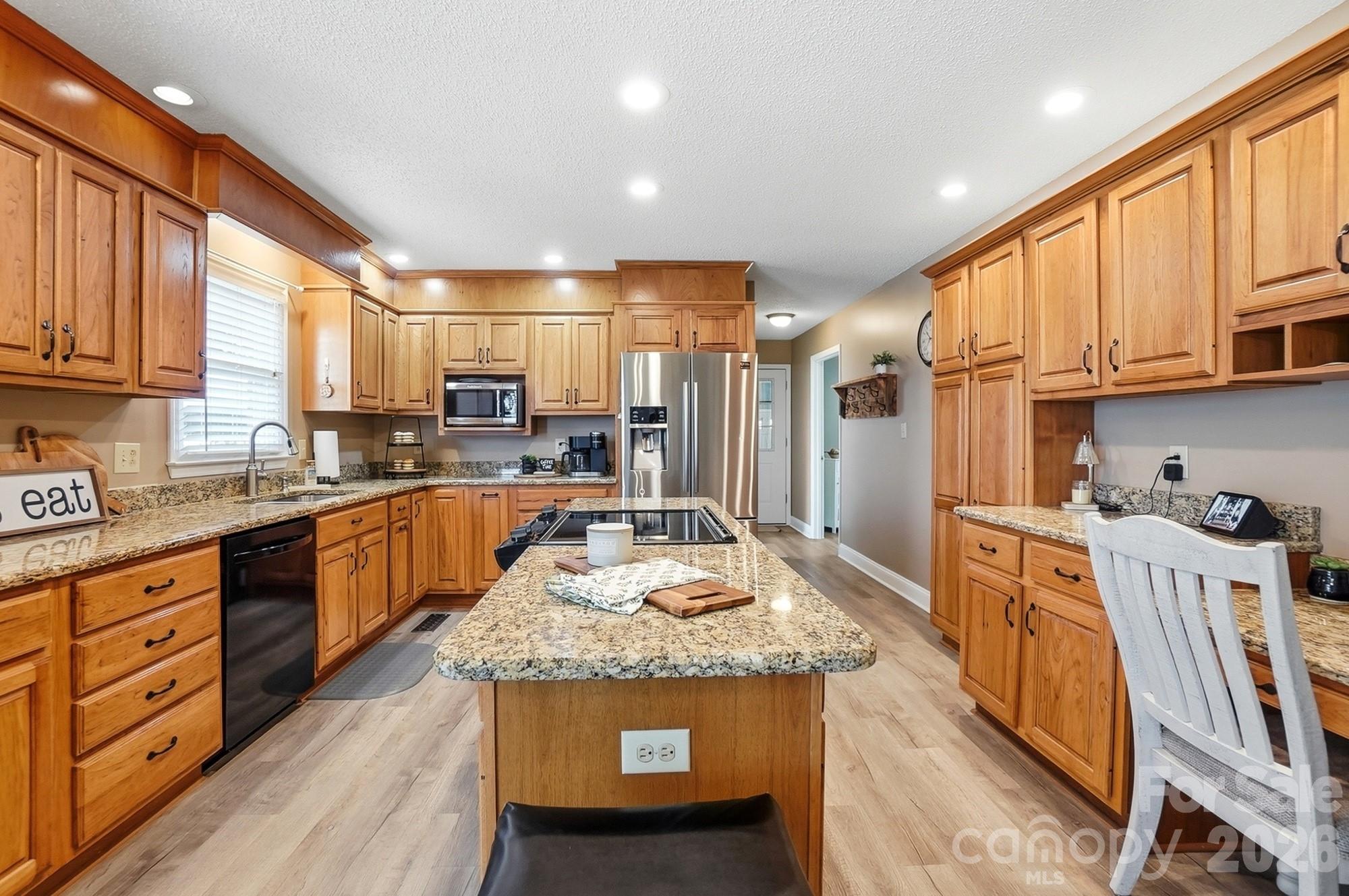 4017 Mullis Newsome Road Monroe, NC 28110 - Photo 17 of 38 a large kitchen with stainless steel appliances granite countertop a lot of counter space and a wooden cabinets