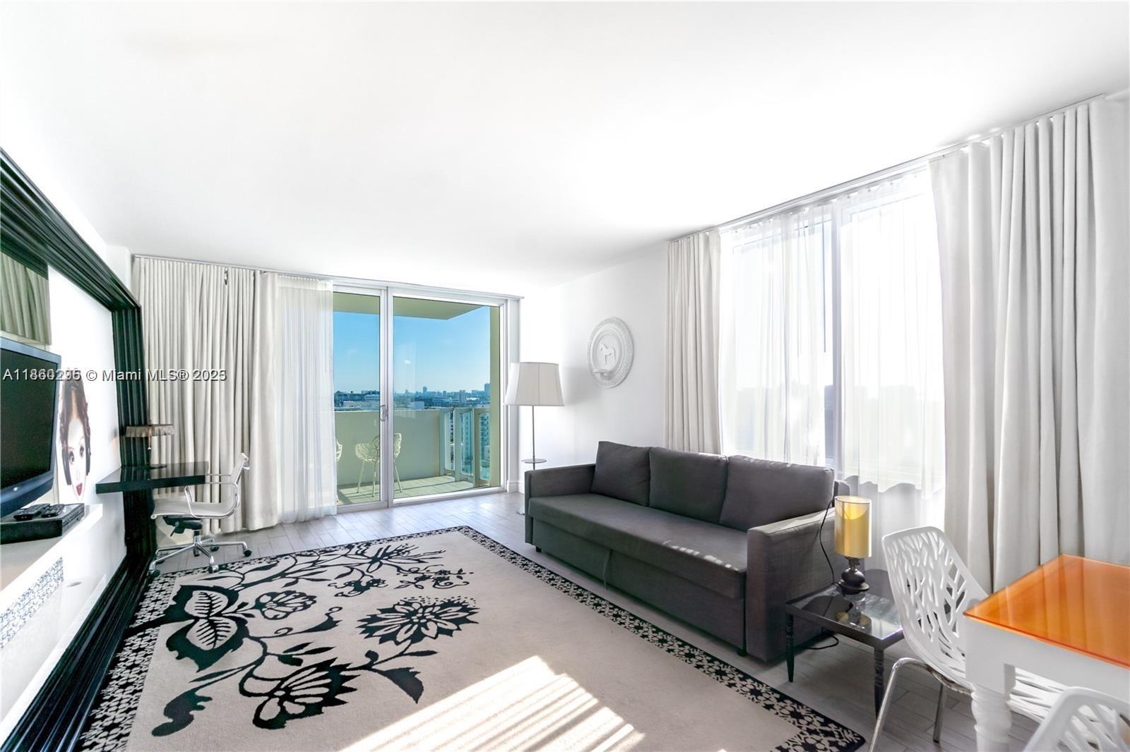 1100 West Avenue, Unit 1402 Miami Beach, FL 33139 - Photo 3 of 58 a living room with a couch and a flat screen tv