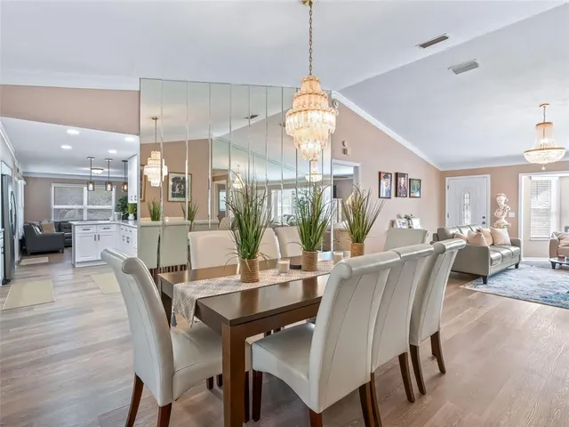 a view of a dining room and livingroom with furniture wooden floor a chandelier