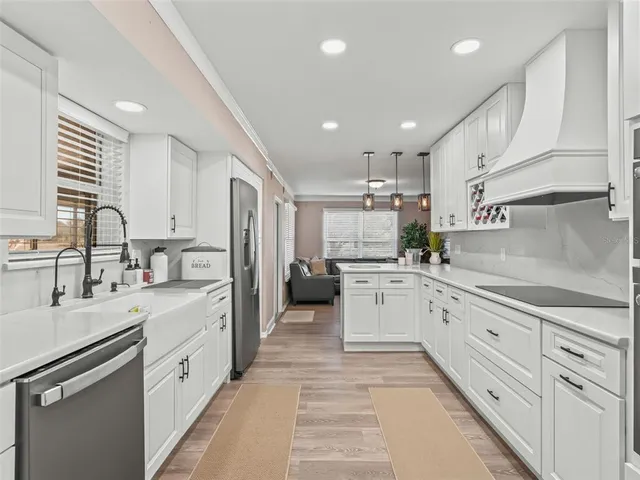 a kitchen with white cabinets and appliances