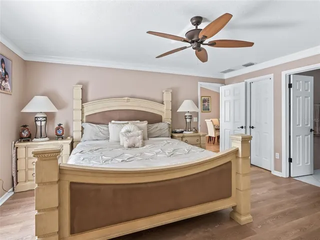 a bed room with a bed a chandelier and a ceiling fan