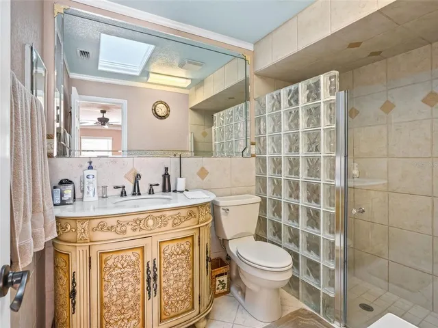 a bathroom with a granite countertop toilet sink and mirror