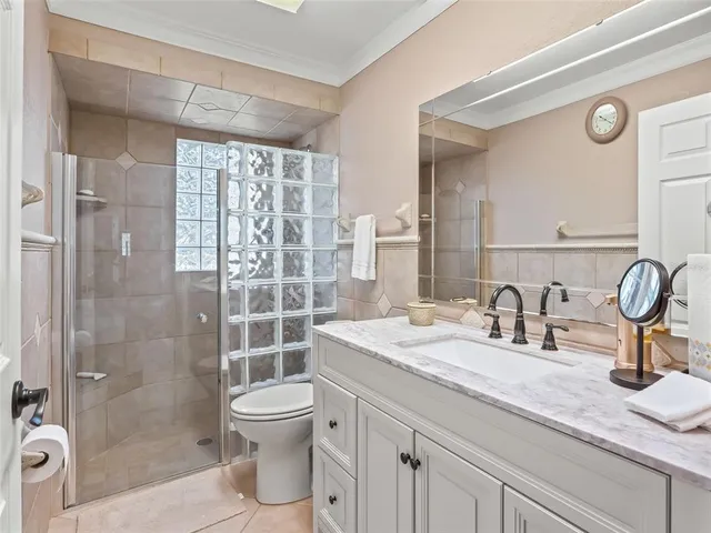 a bathroom with a granite countertop sink a toilet and shower