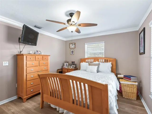 a bedroom with a bed and flat tv screen on dresser