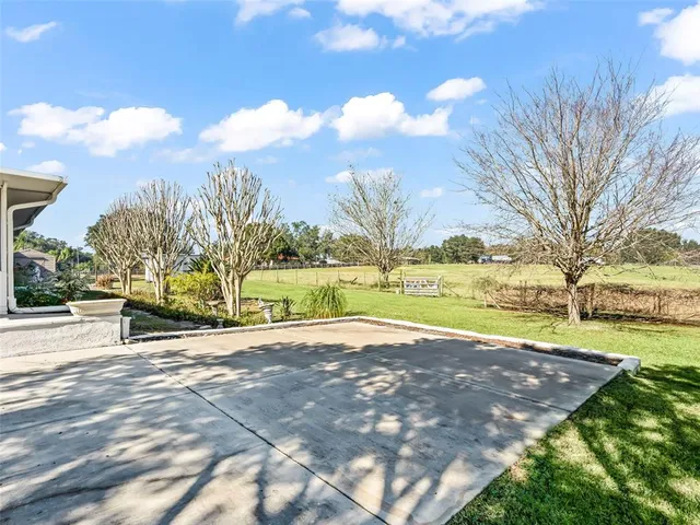 a view of a house with a backyard and a patio