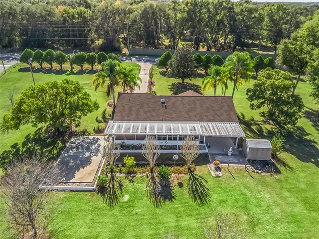 an aerial view of residential houses with outdoor space and trees
