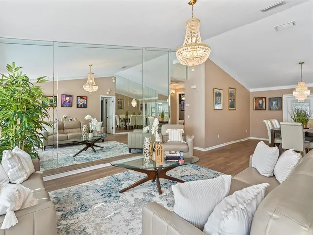 a living room with furniture a chandelier and a dining table
